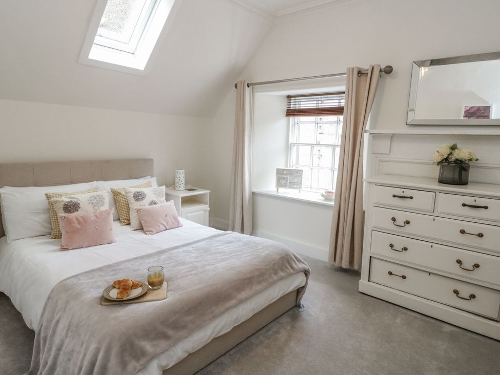 A bedroom with a bed and nightstand at Rowan Tree House in Brechin