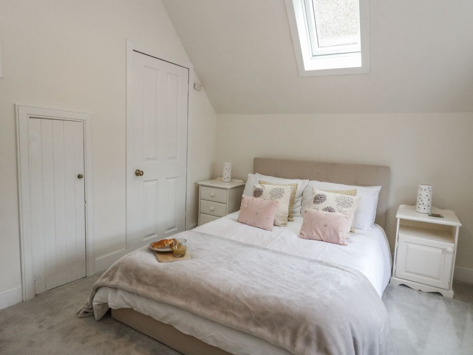 A bedroom with a bed and a bedside table at Rowan Tree House in Brechin