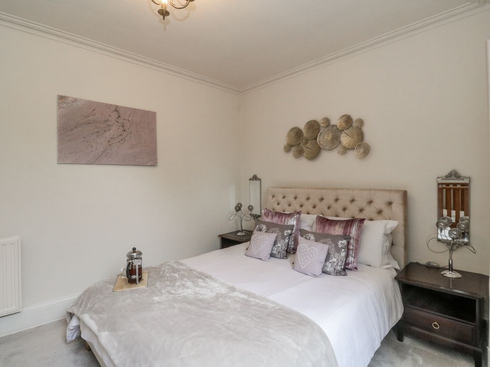 A bedroom with a bed and bedside tables at Rowan Tree House in Brechin