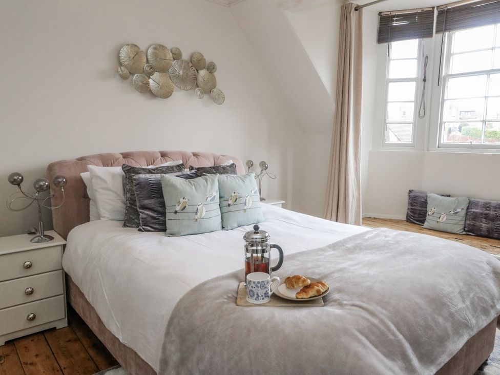 A bedroom with a bed and bedside table at Rowan Tree House in Brechin