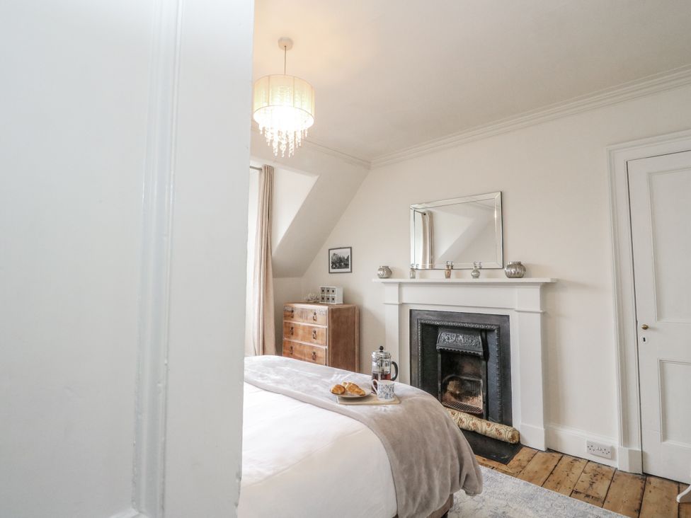 A bedroom with a bed and fireplace at Rowan Tree House Brechin
