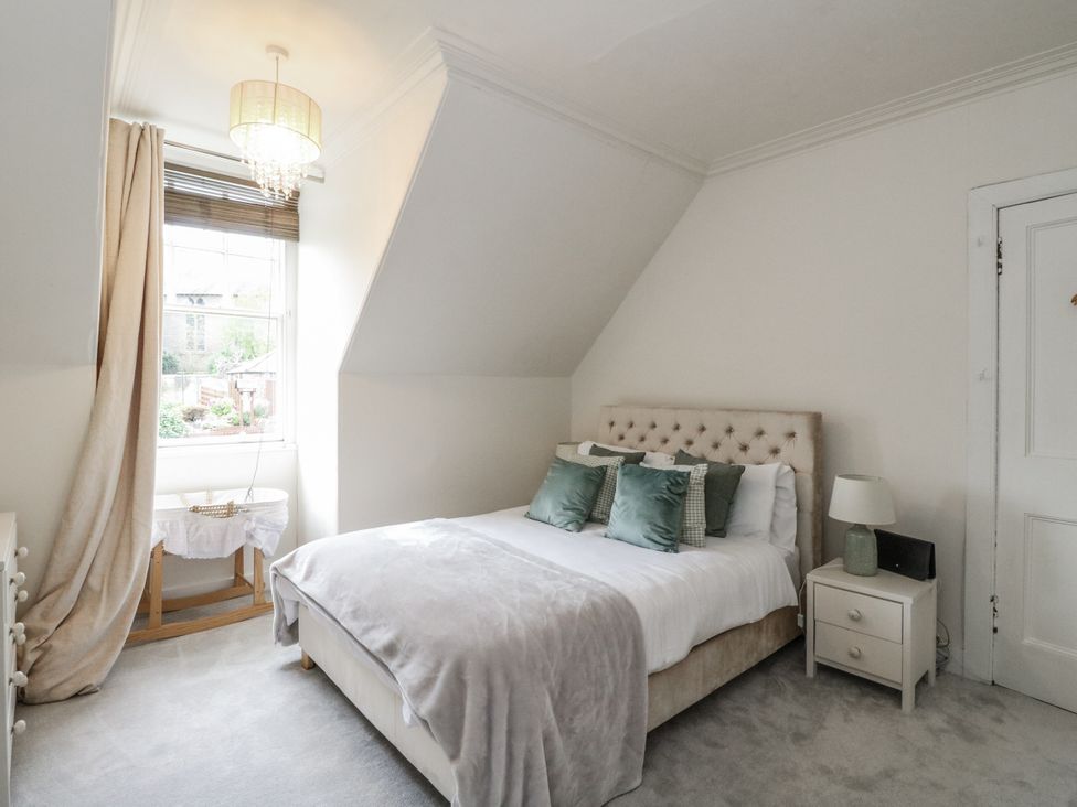 A bedroom with a bed and side table at Rowan Tree House in Brechin