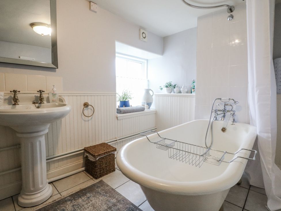 A bathroom with a bathtub and sink at Rowan Tree House in Brechin
