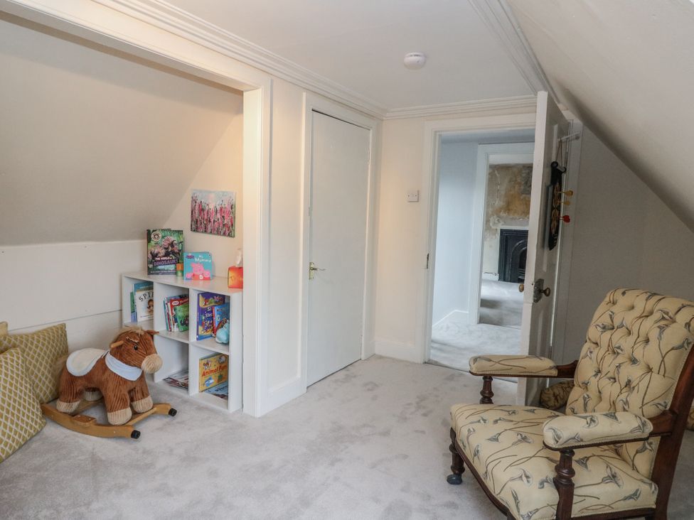 A playroom with books and a rocking horse at Rowan Tree House Brechin
