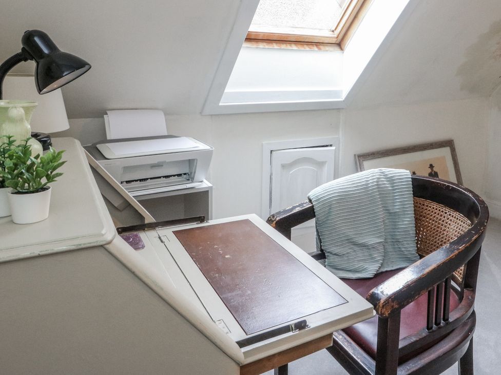 A study with a lamp, printer, and a chair at Rowan Tree House Brechin