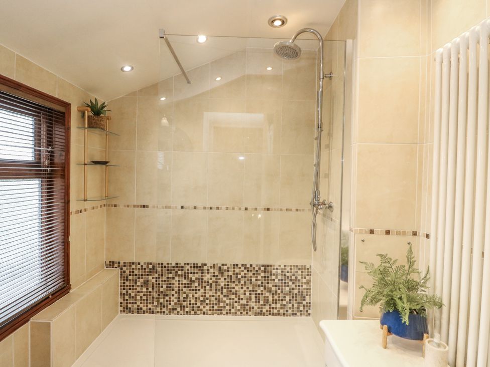 A bathroom with a shower and tiles at Rowan Tree House in Brechin
