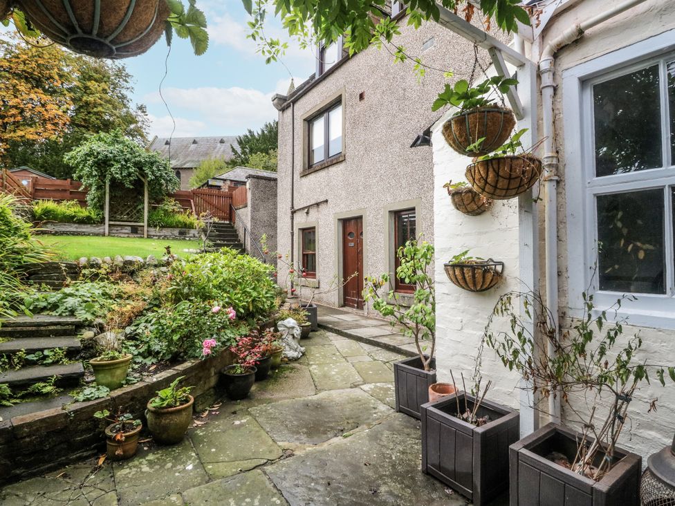 A garden area with stone steps and flower pots at Rowan Tree House Brechin