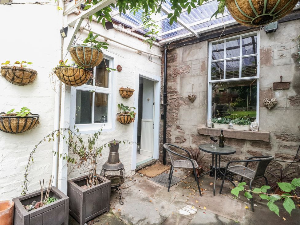 An outdoor area with a table and chairs at Rowan Tree House in Brechin