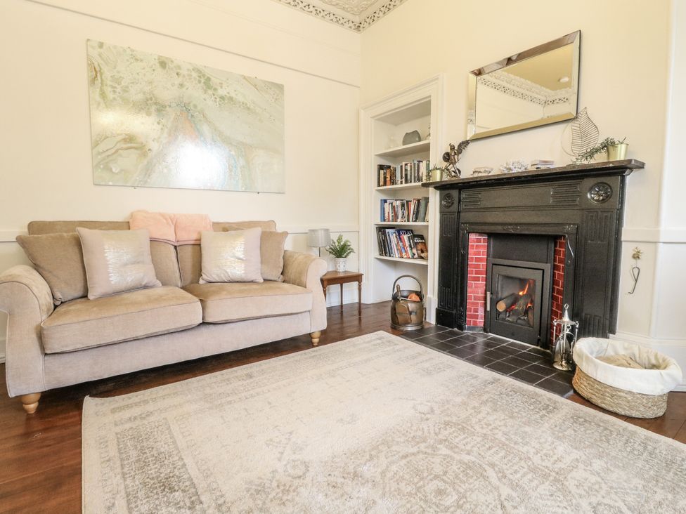 A living room with a fireplace and bookshelf at Rowan Tree House Brechin