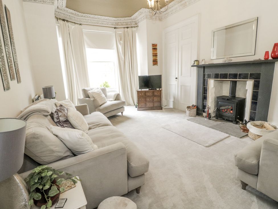 A living room with a fireplace and television at Rowan Tree House Brechin
