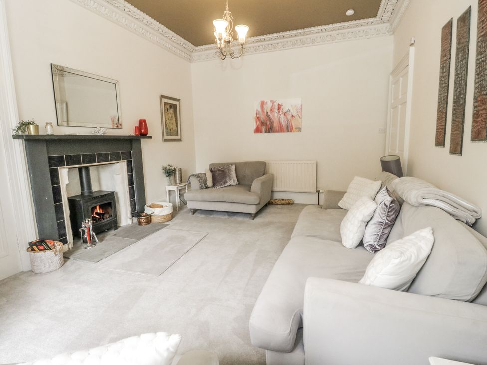 A living room with a fireplace and sofa at Rowan Tree House in Brechin
