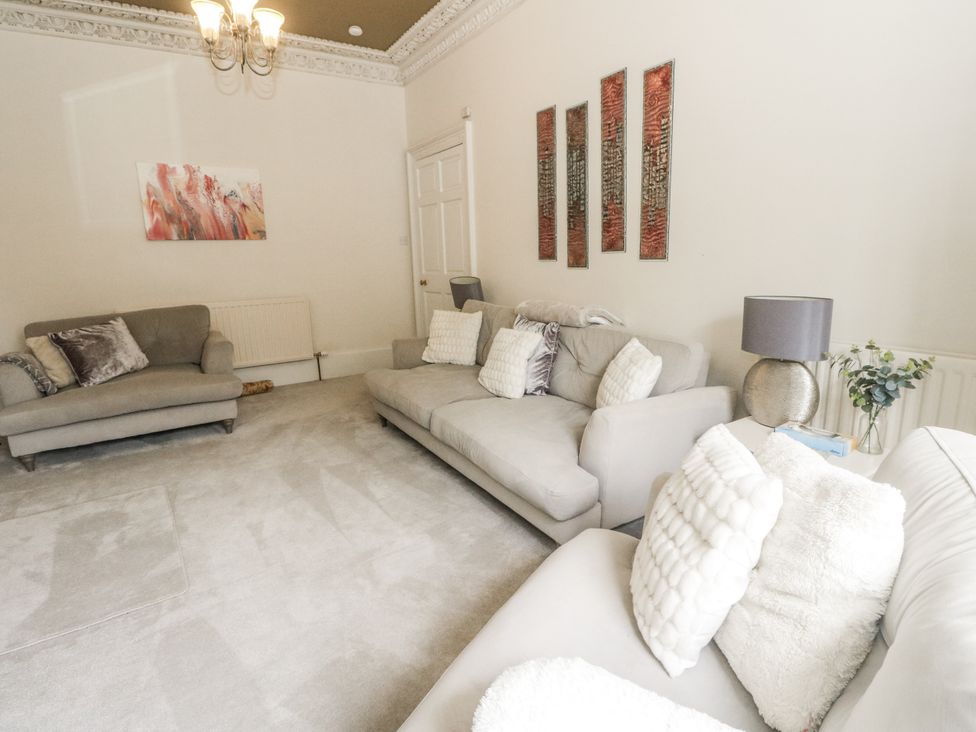 A living room with sofas and wall art at Rowan Tree House in Brechin