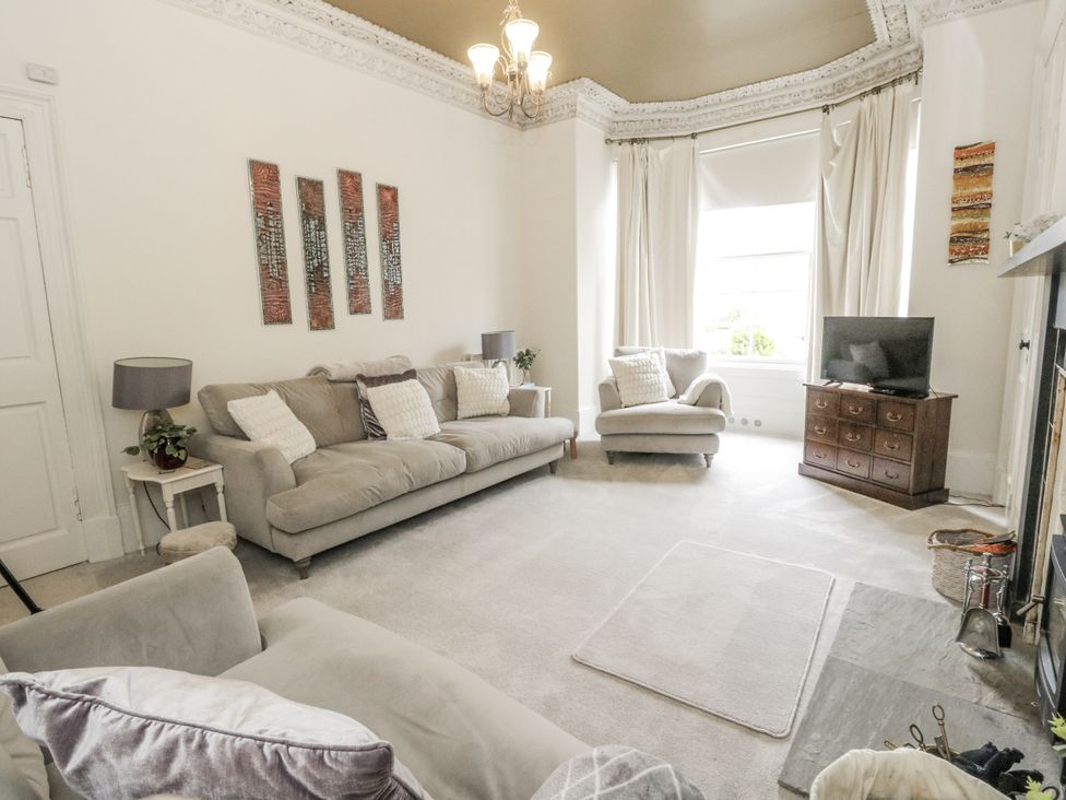 A living room with a sofa and television at Rowan Tree House in Brechin