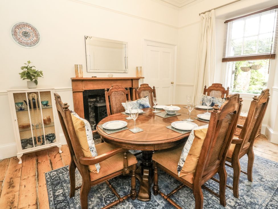 A dining room with a round table and chairs at Rowan Tree House in Brechin