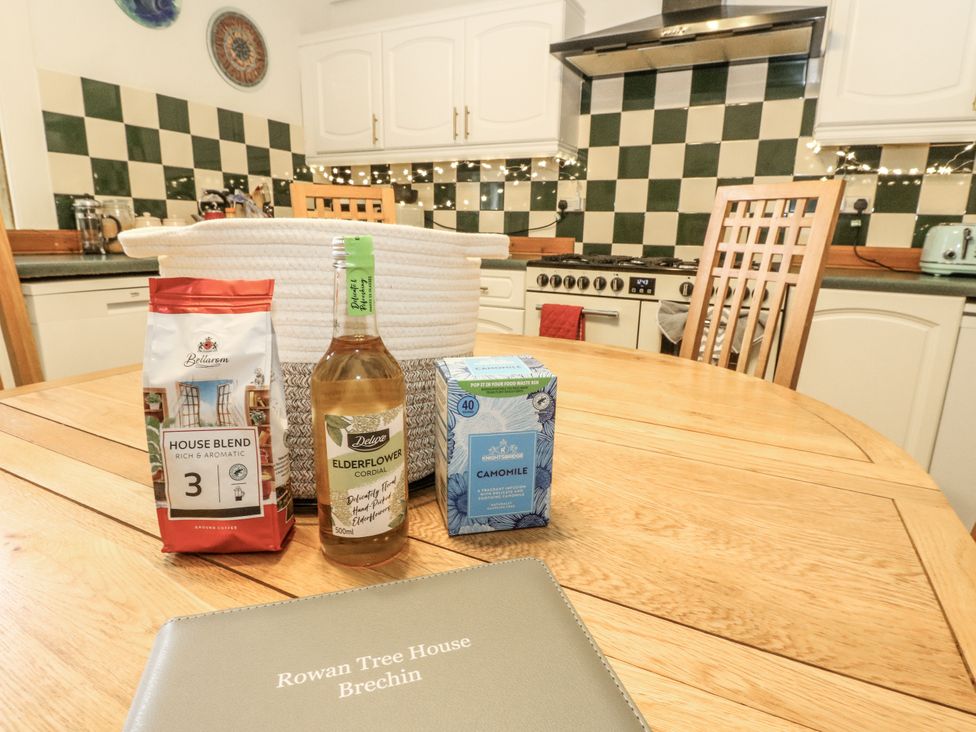 A kitchen with a wooden table and chairs at Rowan Tree House Brechin