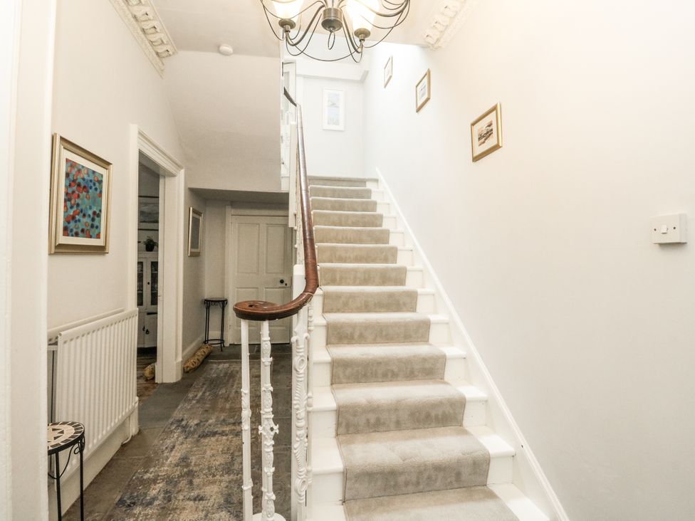 A hallway with a staircase and artwork at Rowan Tree House in Brechin