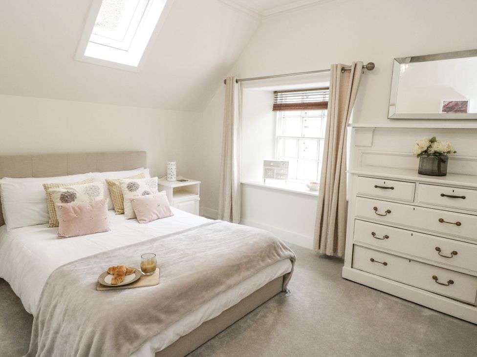 A bedroom with a bed and dresser at Rowan Tree House in Brechin