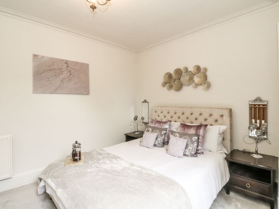 A bedroom with a bed and bedside tables at Rowan Tree House in Brechin