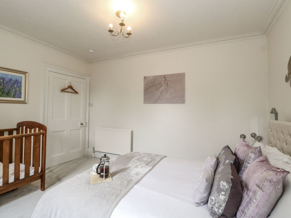 A bedroom with a bed and a cot at Rowan Tree House in Brechin