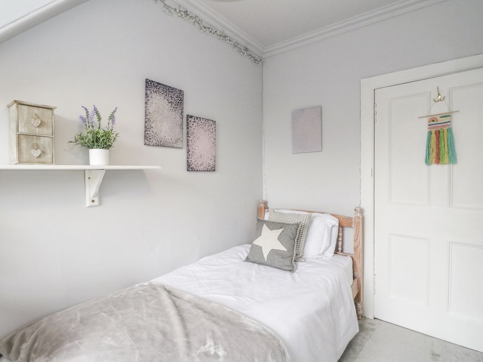 A bedroom with a bed and wall art at Rowan Tree House Brechin