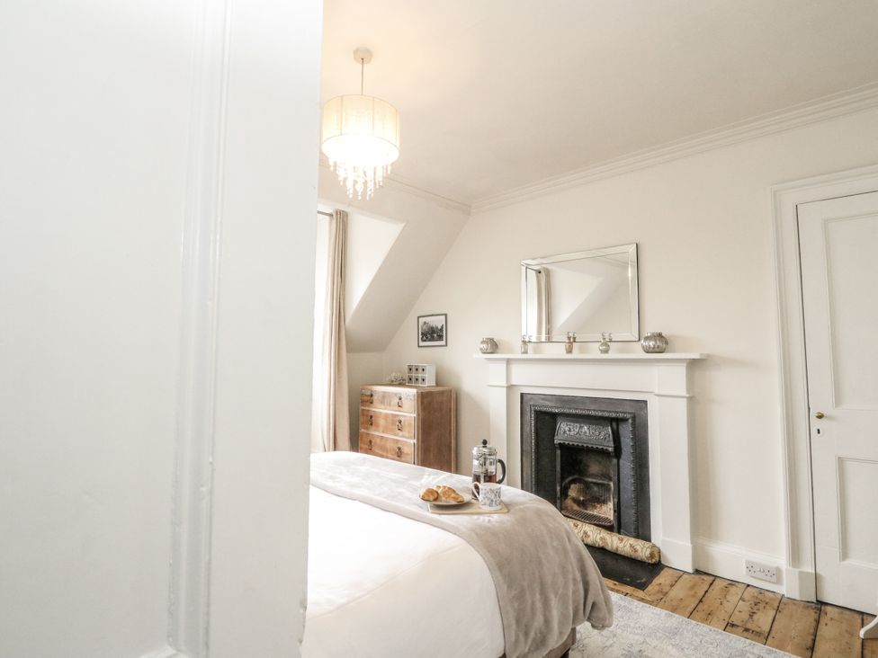 A bedroom with a bed and fireplace at Rowan Tree House in Brechin