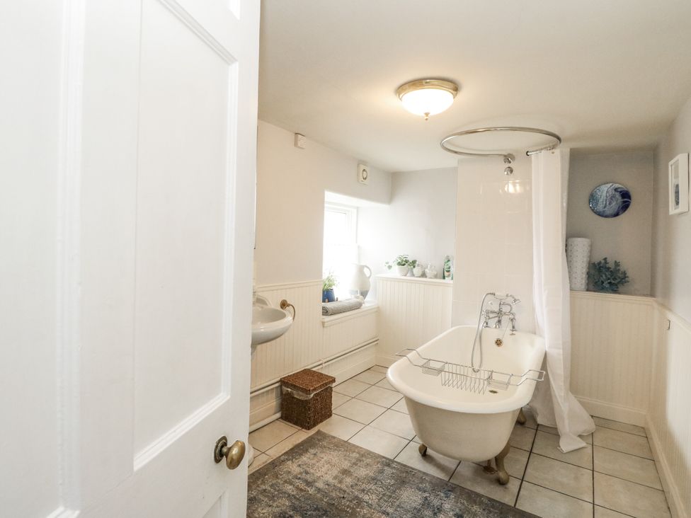 A bathroom with a bathtub and sink at Rowan Tree House Brechin