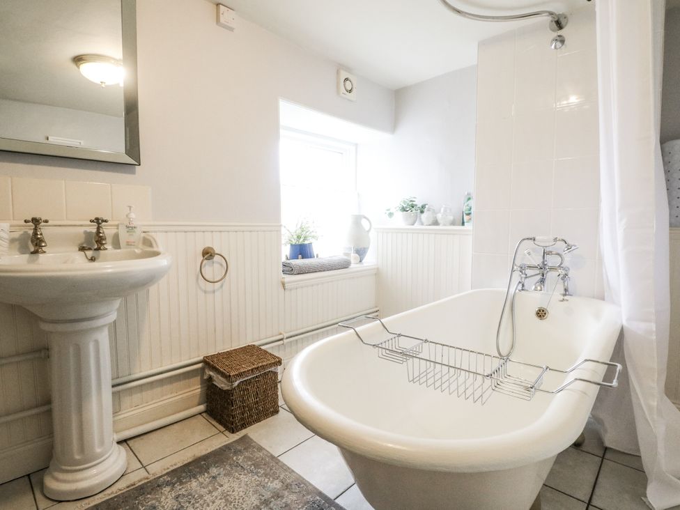 A bathroom with a bathtub and sink at Rowan Tree House in Brechin