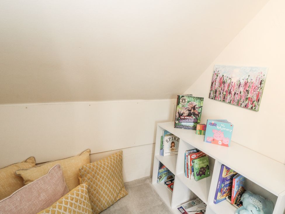 A children's reading nook with books and cushions at Rowan Tree House Brechin
