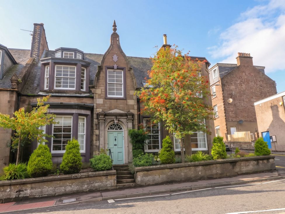 A house with multiple windows and a door at Rowan Tree House in Brechin