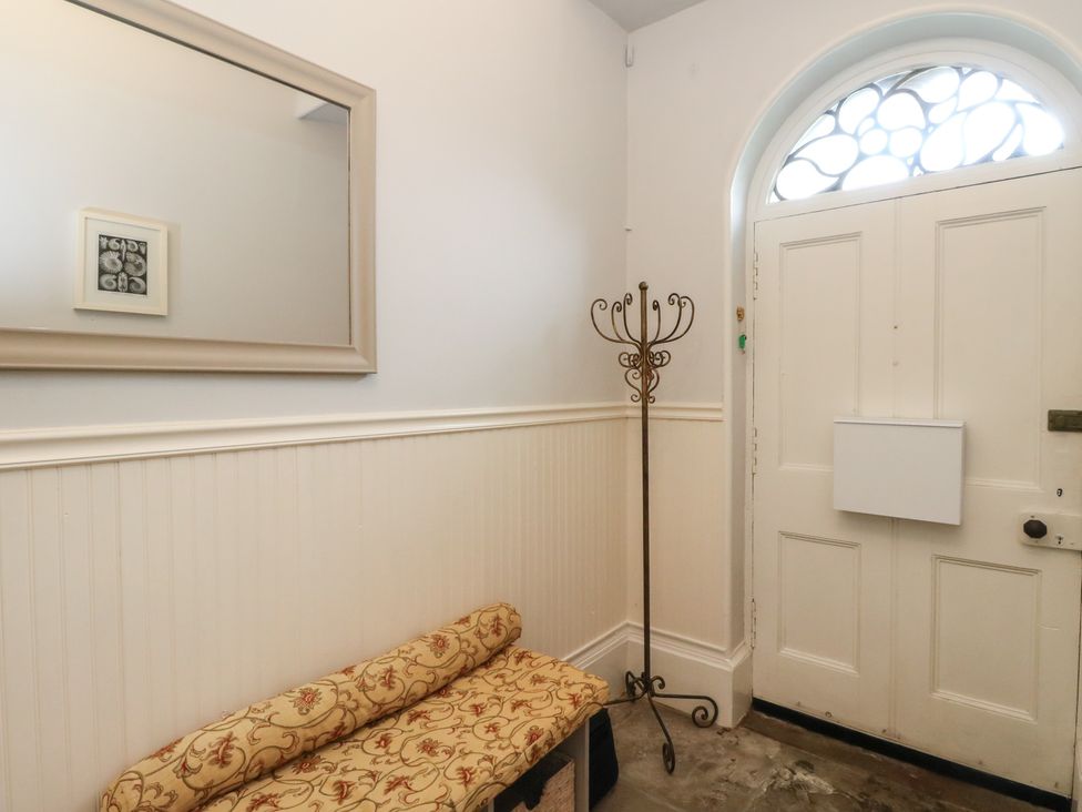 A hallway with a bench and coat rack at Rowan Tree House Brechin
