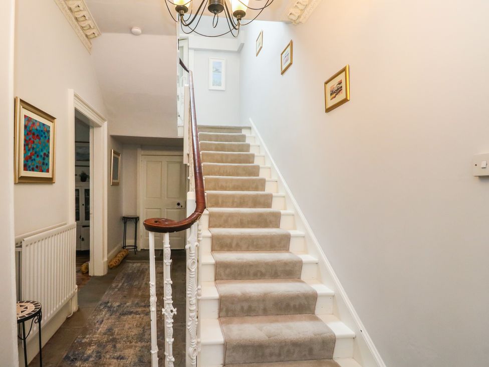 A staircase with photographs on the wall at Rowan Tree House in Brechin