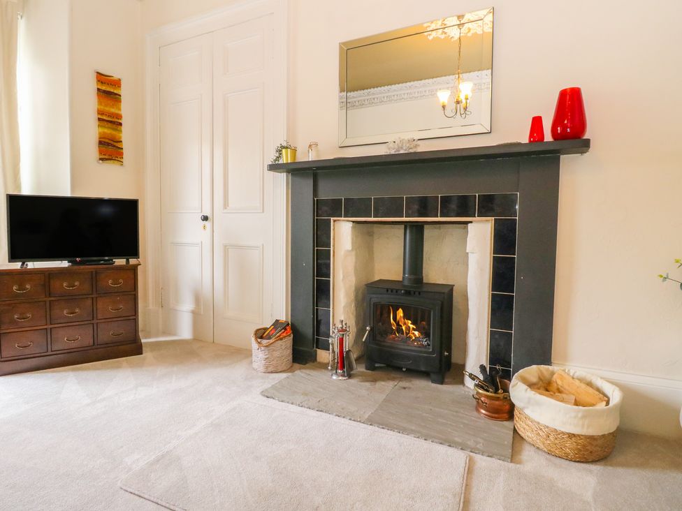 A living room with a fireplace and television at Rowan Tree House Brechin