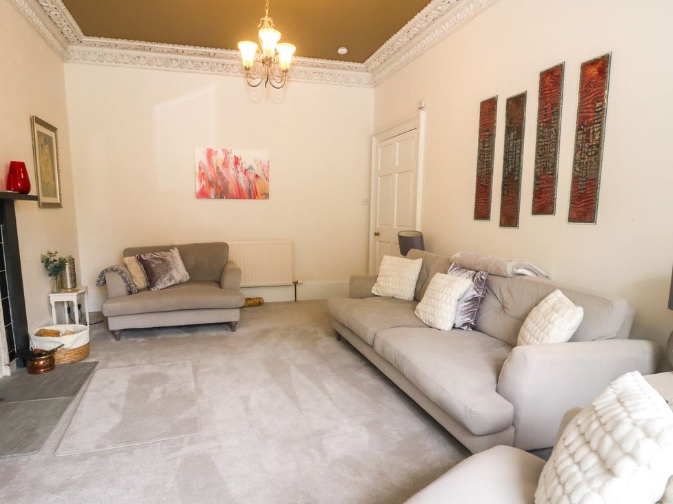 A living room with sofas and a fireplace at Rowan Tree House in Brechin