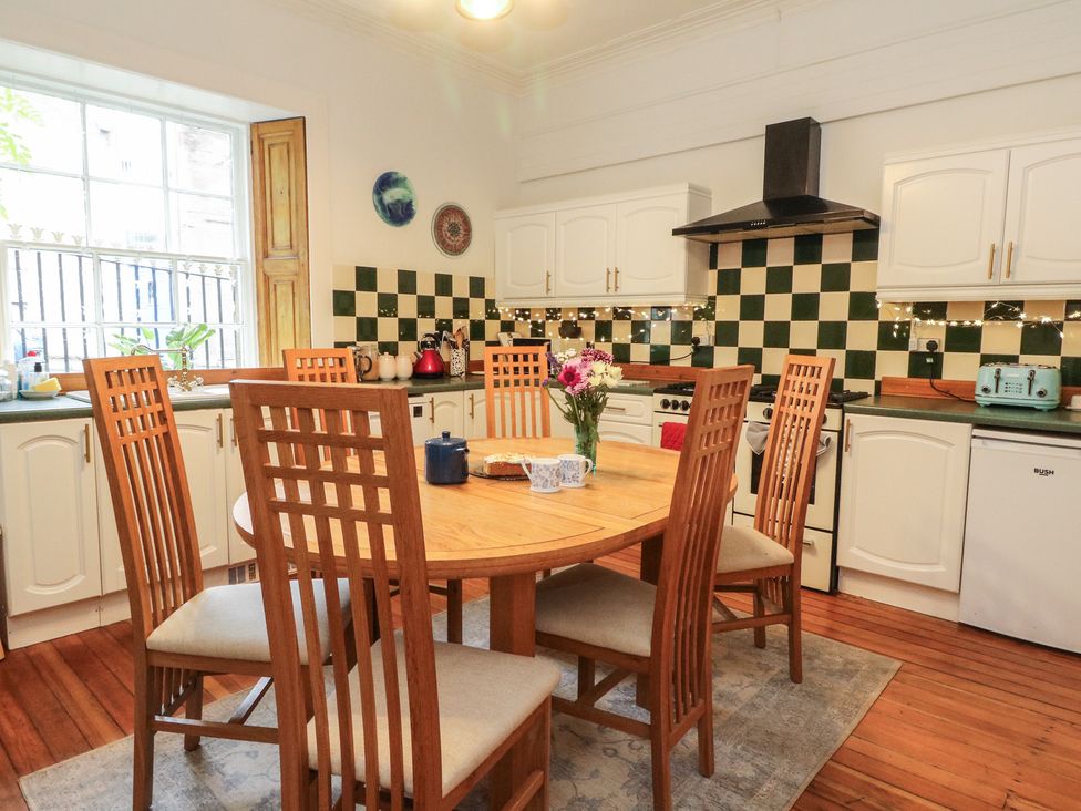 A kitchen with a dining table and chairs at Rowan Tree House in Brechin