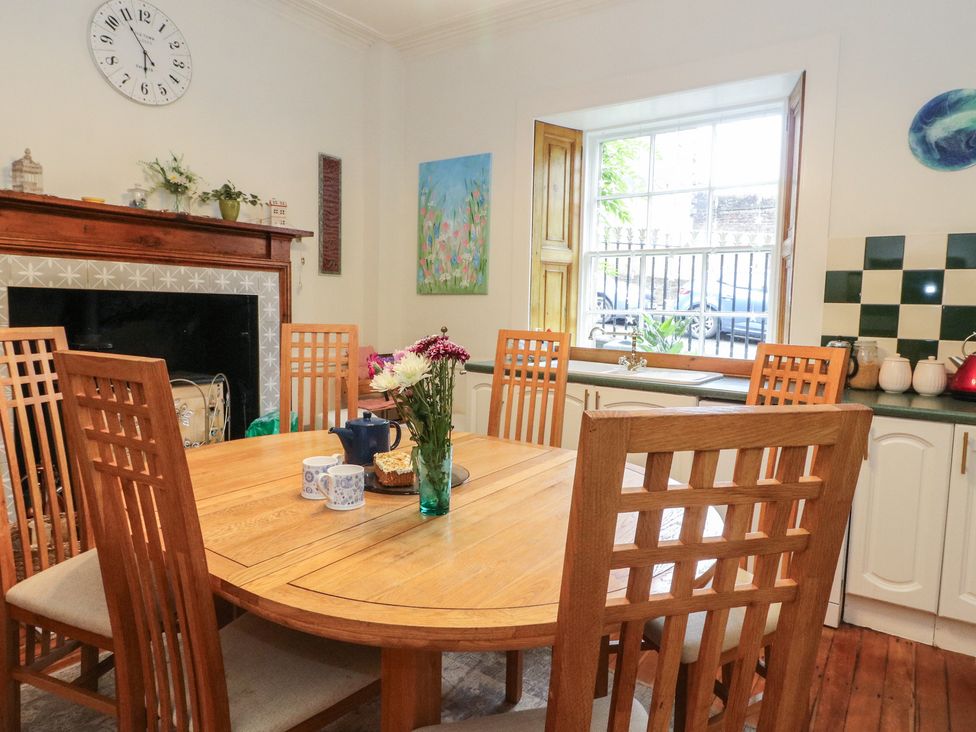 A dining room with a round table and chairs at Rowan Tree House in Brechin