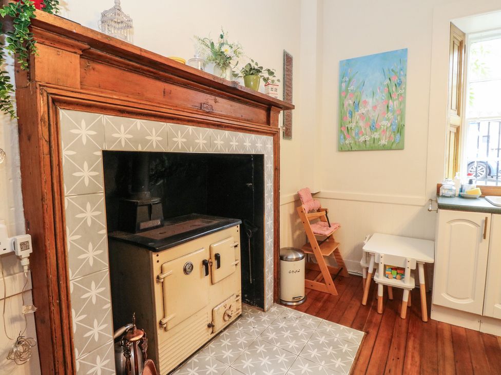 A kitchen with a wood stove and high chair at Rowan Tree House Brechin