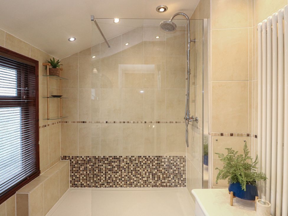 A bathroom with a shower and towel radiator at Rowan Tree House in Brechin