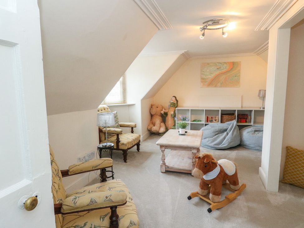 A playroom with a rocking horse and stuffed toys at Rowan Tree House in Brechin