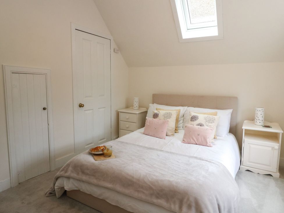 A bedroom with a bed and nightstands at Rowan Tree House in Brechin