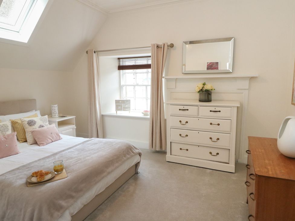 A bedroom with a bed and a window at Rowan Tree House Brechin