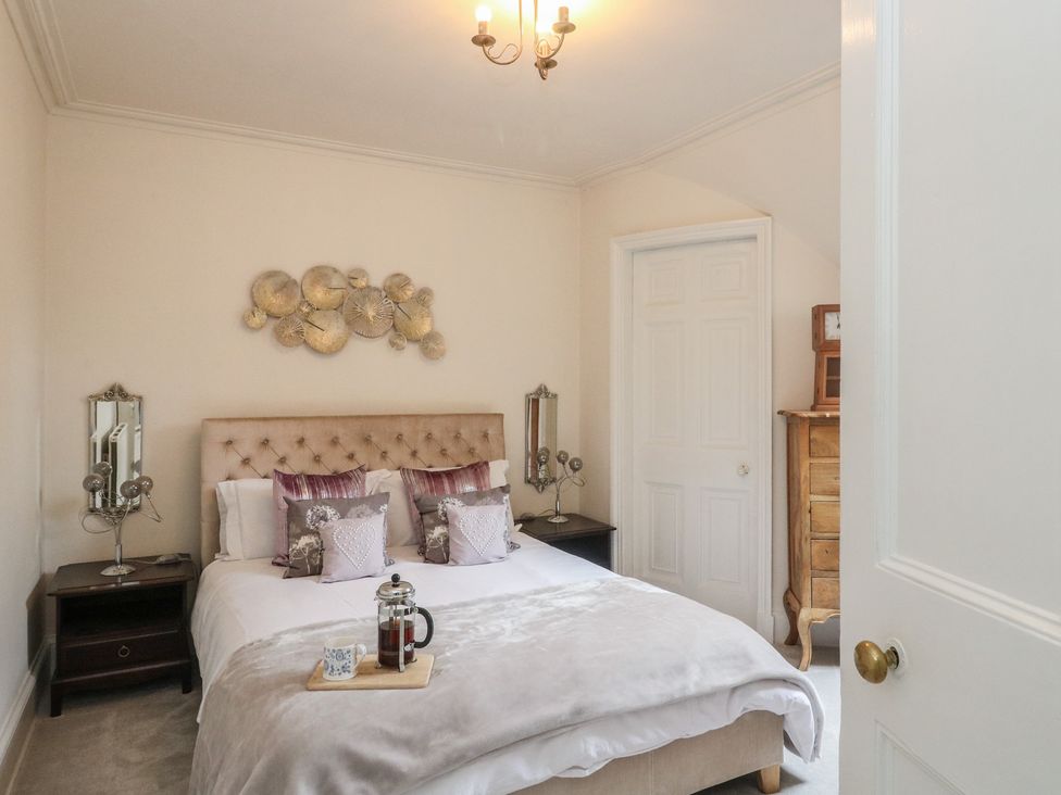 A bedroom with a bed and nightstands at Rowan Tree House in Brechin
