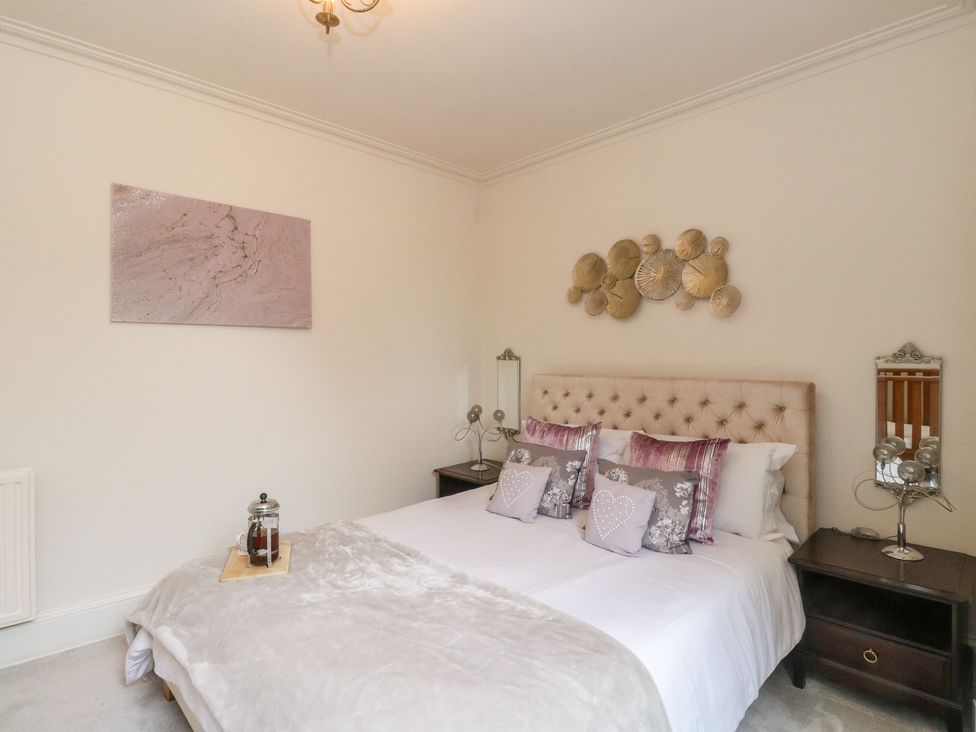 A bedroom with a bed and bedside tables at Rowan Tree House in Brechin