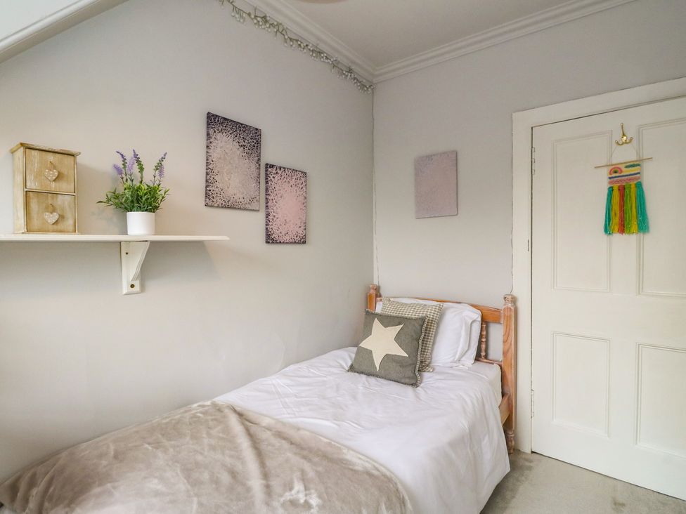 A bedroom with a bed and shelf at Rowan Tree House in Brechin