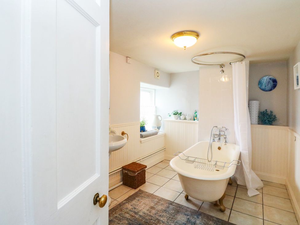 A bathroom featuring a bathtub and sink at Rowan Tree House in Brechin