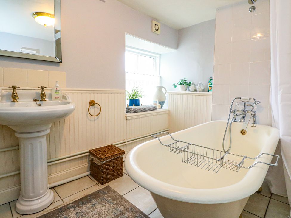 A bathroom with a bathtub and sink at Rowan Tree House Brechin