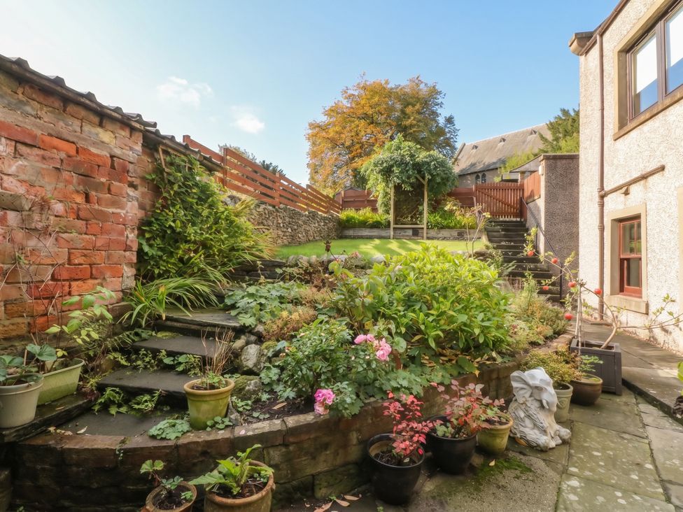 A garden with stone steps and planters at Rowan Tree House Brechin