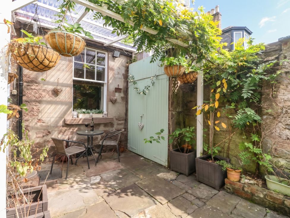 A garden area with a table and chairs at Rowan Tree House Brechin