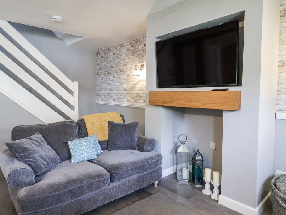 A living room with a sofa and television at Rushmoor Cottage in Colaton Raleigh