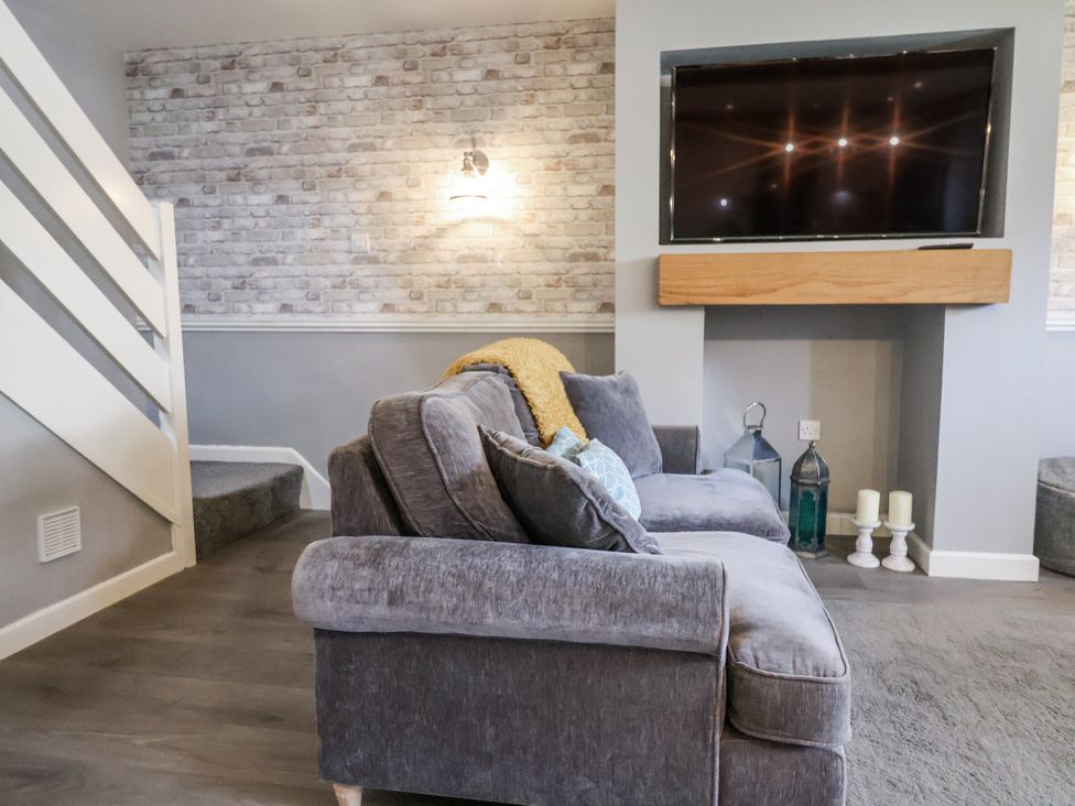 A living room with a sofa and television at Rushmoor Cottage in Colaton Raleigh
