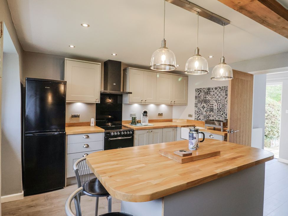 A kitchen with a refrigerator and oven at Rushmoor Cottage in Colaton Raleigh